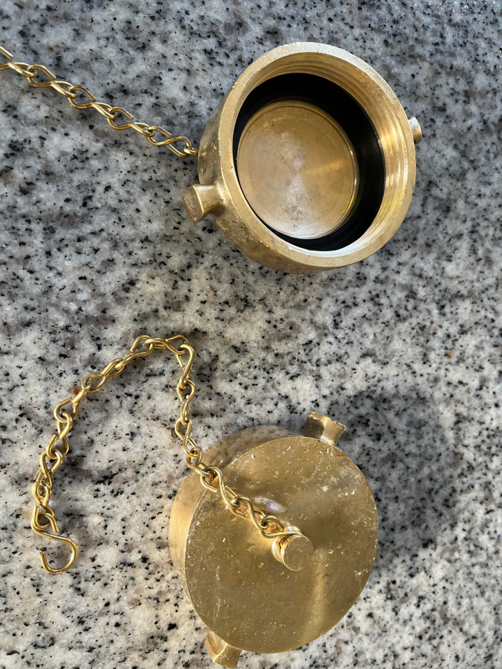 A gold circular object with a chain on a marble surface.