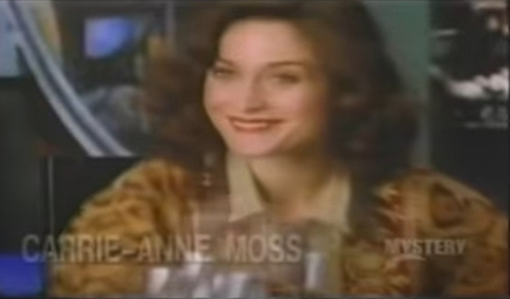 Low quality still of Carrie-Anne Moss smiling from Matrix TV series.