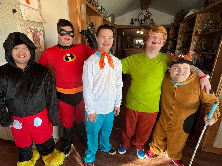 Five young men with Down syndrome wearing cartoon costumes.