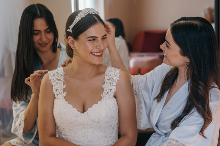 A bride getting ready with her two bridemaids.
