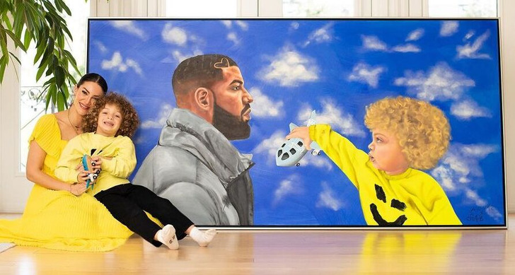 A paint of Drake and his son in the living room with his son and his mother posing in front of it.