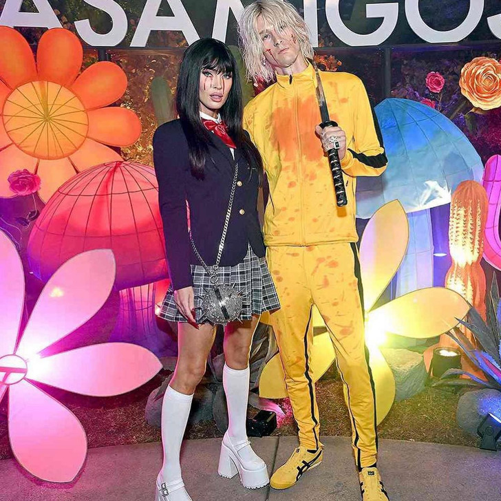 Megan Fox in a blue coat and checked mini skirt, MGK in a yellow tracksuit holding a sword.