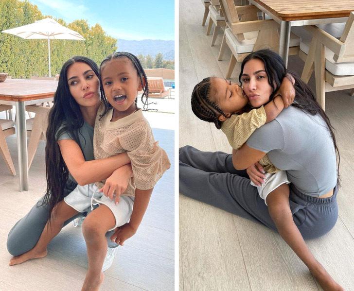 Kim Kardashian and her son embracing each other beside a table on wooden flooring.
