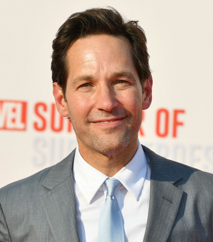 Close-up of a portrait of Paul Rudd in a grey suit and blue tie.
