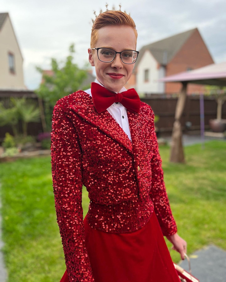 Boy wearing a red suit with sequins and red lipstick