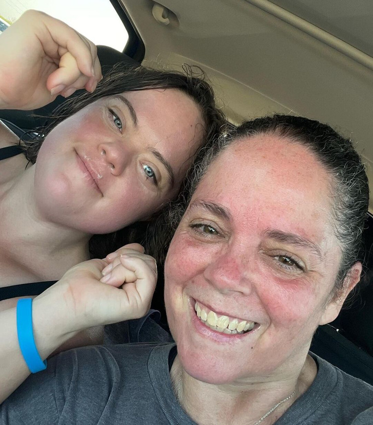 Two women taking a close-up selfie inside a car.