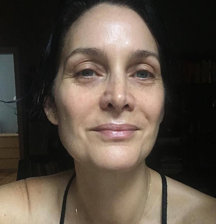 Close-up of make-up free Carrie-Anne Moss, black strappy top.