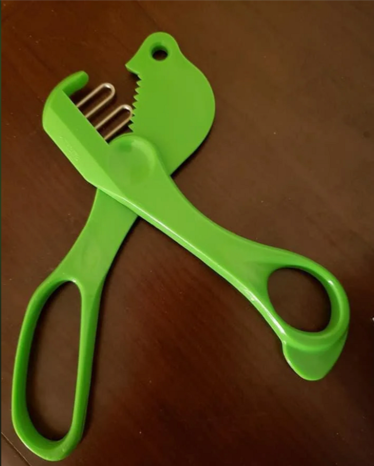 A a green tool on a table that has scissors like handles.